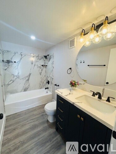 A bathroom with a marble wall and a round mirror.