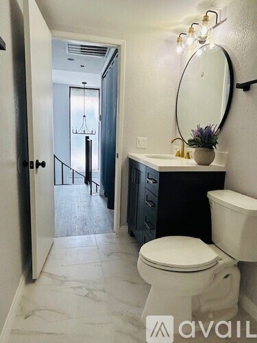 A bathroom with a toilet, sink, and mirror.