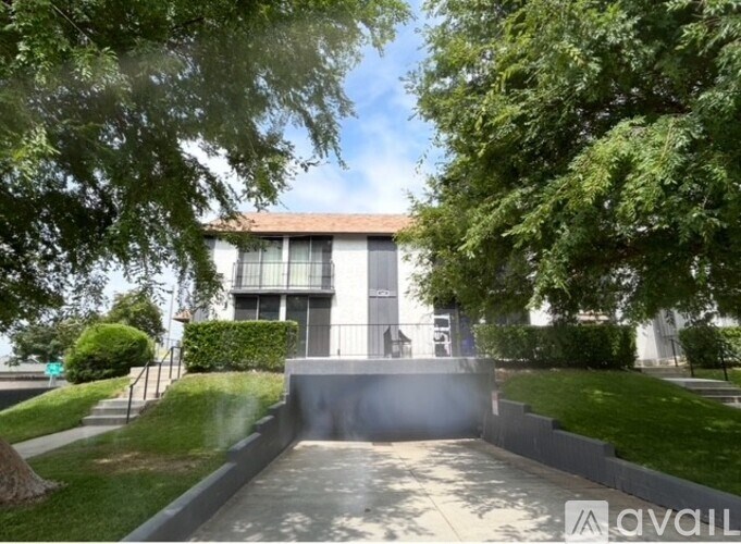 A house with a driveway and greenery in front.