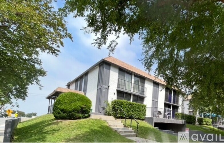 A house with a green lawn and trees in front.