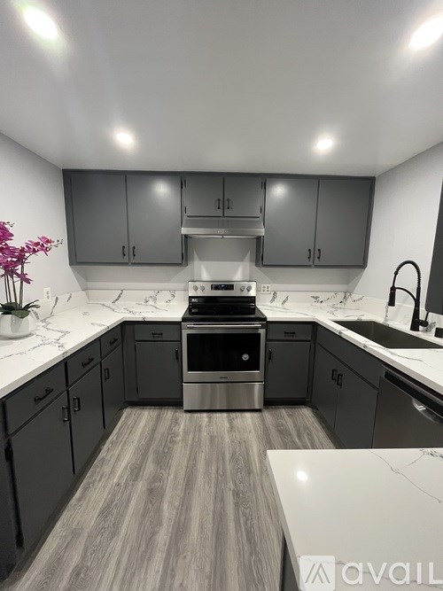 A kitchen with a stove top oven and a sink.