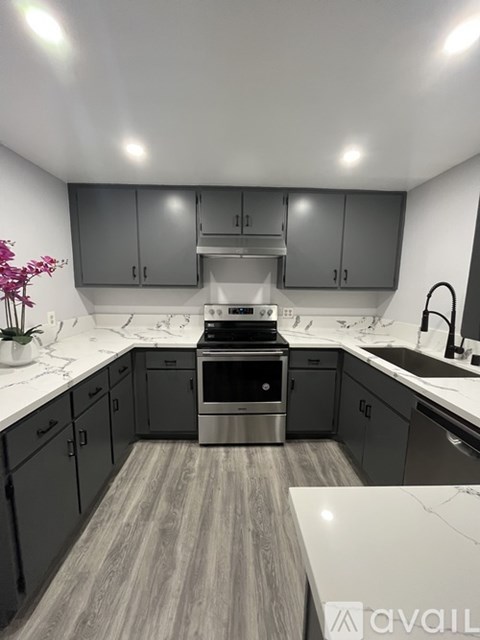 A kitchen with a stove top oven and a sink.