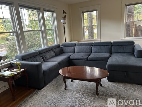 A grey sectional sofa in a living room with a wooden coffee table.