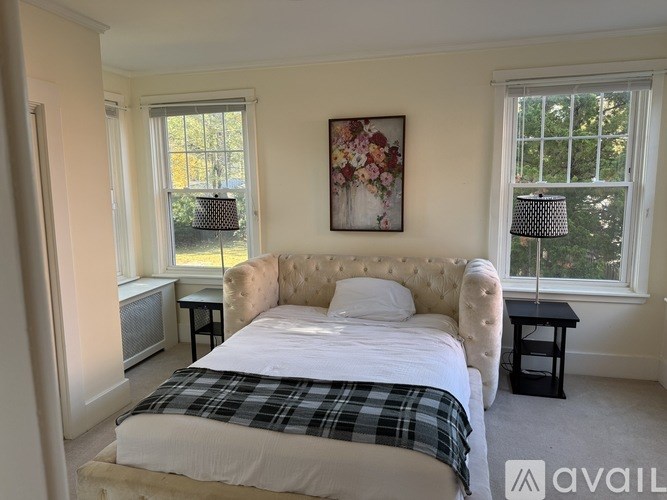 A bedroom with a large bed and a painting on the wall.