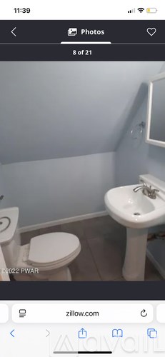 A white toilet and sink in a small bathroom.