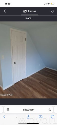 A white door in a room with wooden flooring.