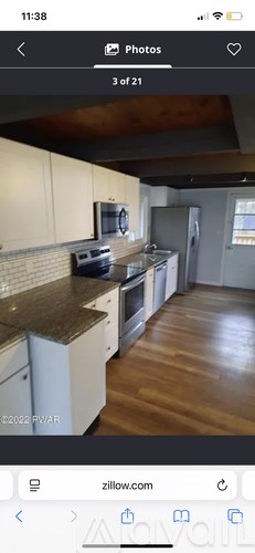 A kitchen with white cabinets and a brown countertop.