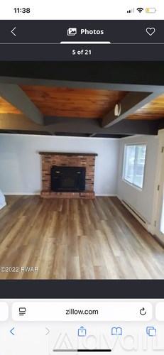 A room with a fireplace and wooden flooring.