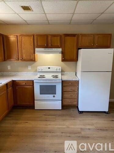 A kitchen with wooden cabinets and a white refrigerator.