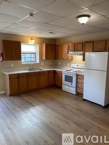 A kitchen with wooden cabinets and a white refrigerator.