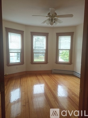 A room with wooden floors and a ceiling fan.