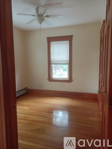 A room with wooden floors and a ceiling fan.