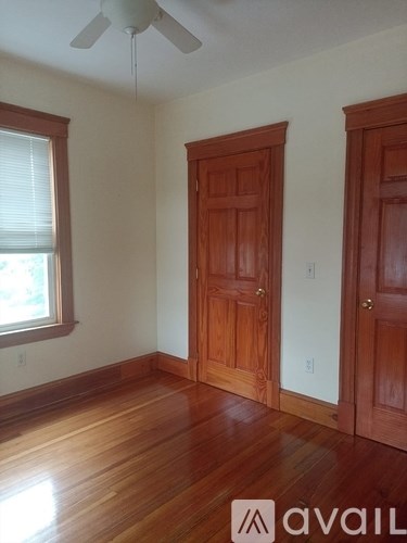 A room with a wooden floor and a ceiling fan.