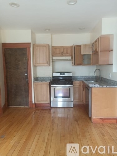 A kitchen with wooden floors and a stainless steel stove.