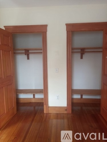 A room with two wooden doors and a bench under the doors.