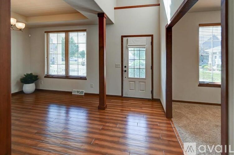 A room with wooden floors and a door leading to a balcony.