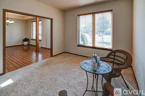 A living room with a round table and a chair.