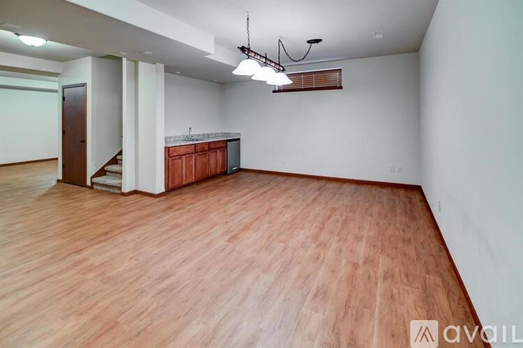 A room with wooden flooring and a bar area.
