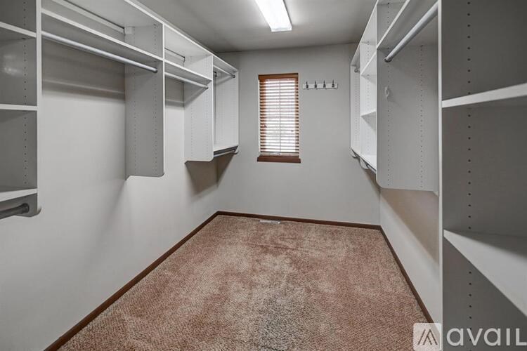 A room with white shelves and a brown carpet.