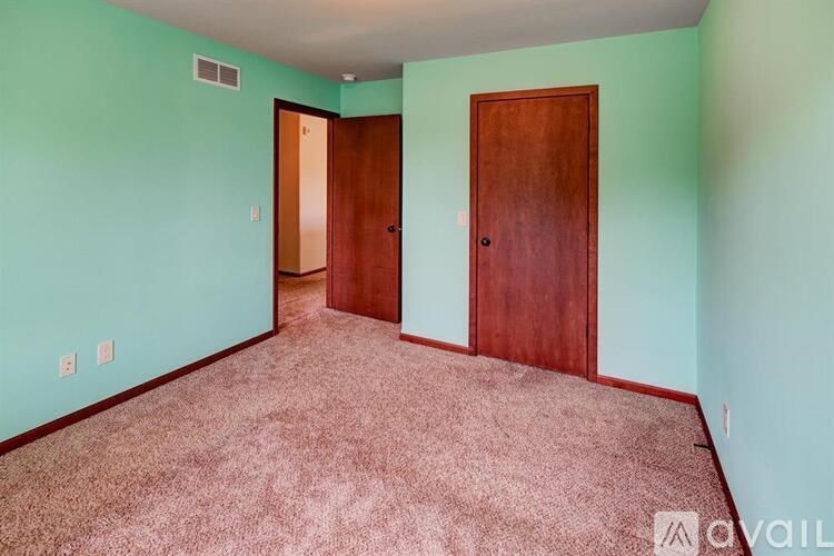 A room with two doors and carpeted floor.