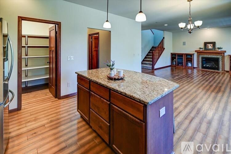 A kitchen with a granite countertop and wooden floors.
