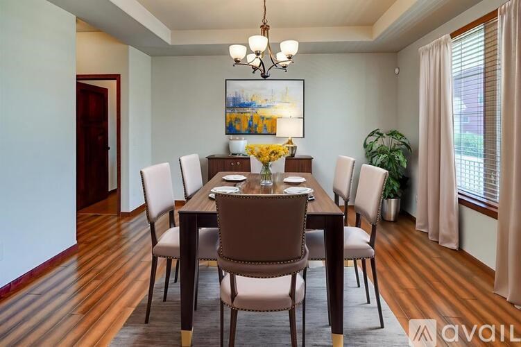 A dining room with a wooden table and chairs.