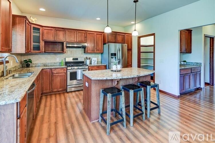 A kitchen with wooden cabinets and a granite countertop.