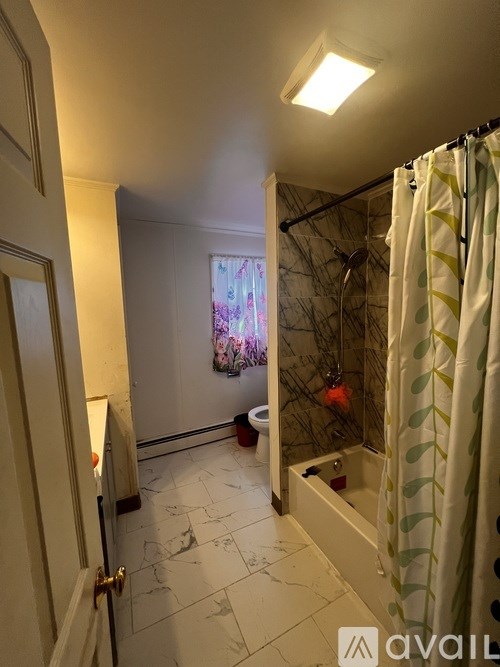 A bathroom with a shower, toilet, and sink.