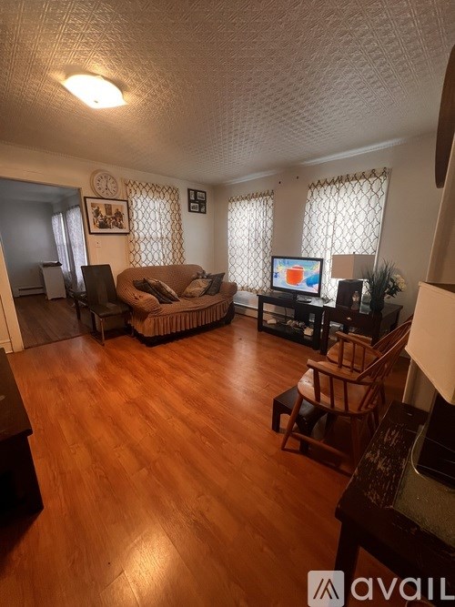 A living room with a couch, chair, and television.