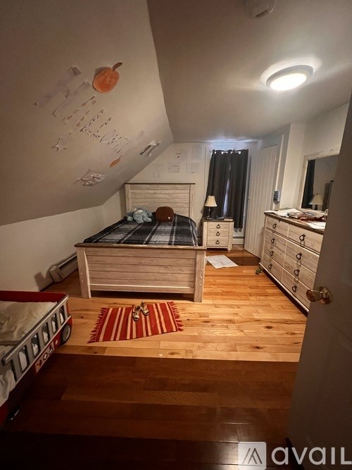 A bedroom with a bed, dresser, and mirror.