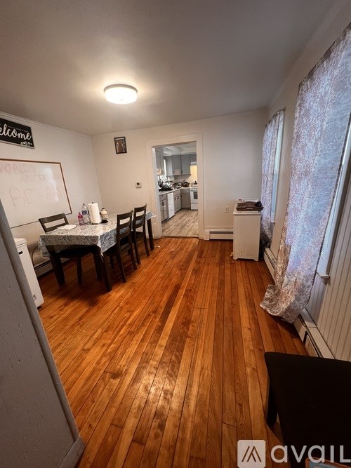 A room with wooden floors and a whiteboard on the wall.