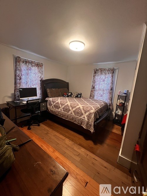 A bedroom with a bed, desk, and chair.