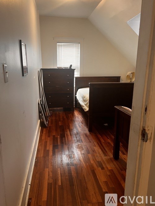 A room with a bed and a dresser in it.