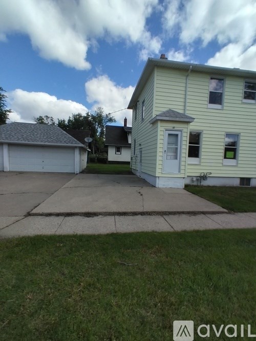 A house with a white garage door and a grey roof.