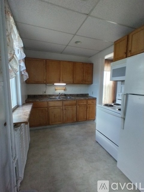 A kitchen with wooden cabinets and a white refrigerator.