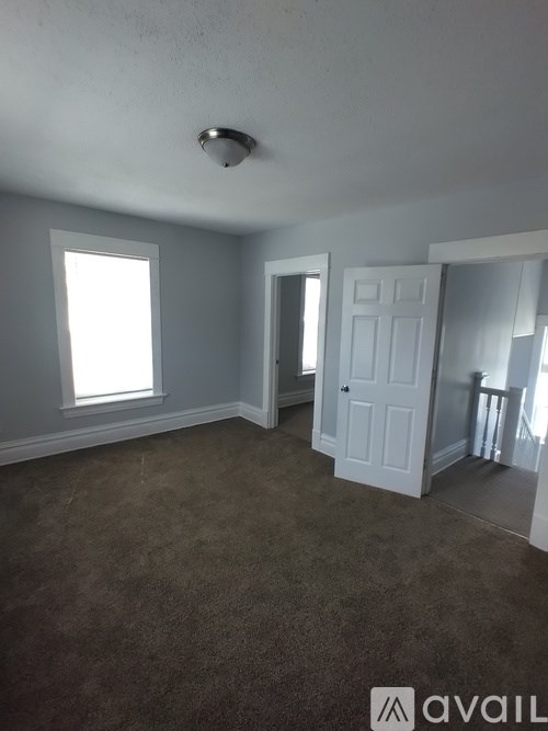 A room with a carpeted floor and a white door.
