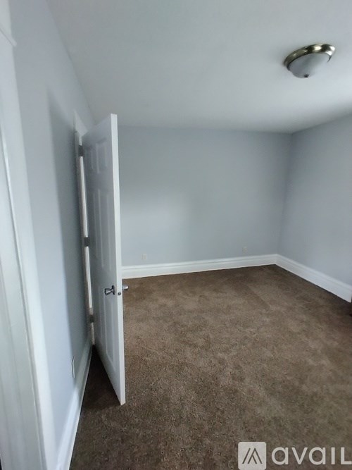 A room with a carpeted floor and a white door.