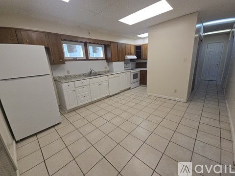 A kitchen with white appliances and brown cabinets.