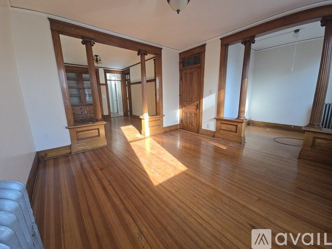 A room with wooden floors and a large mirror on the wall.