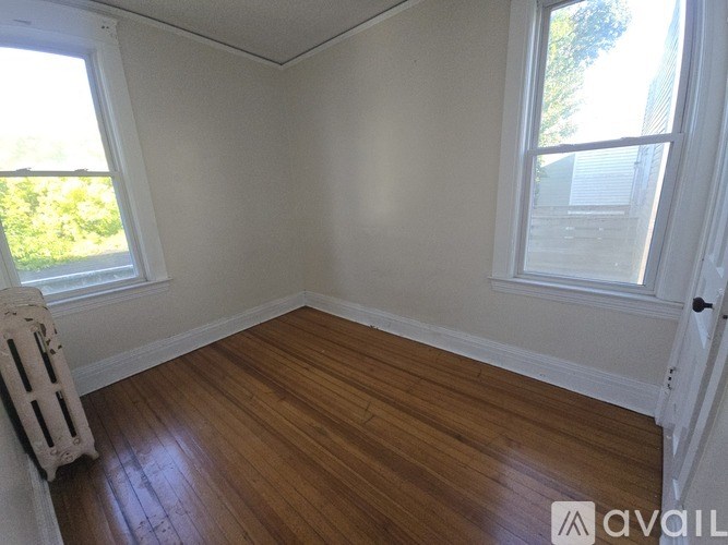 A room with wooden floors and two windows.