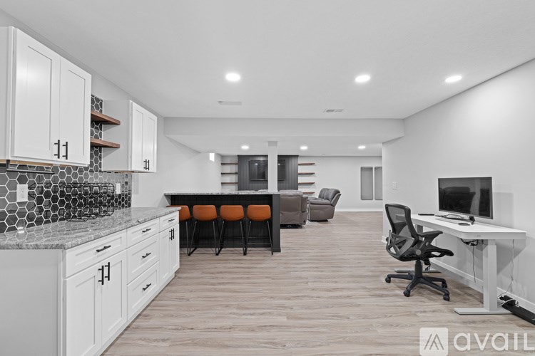 A modern kitchen with white cabinets and a marble countertop.