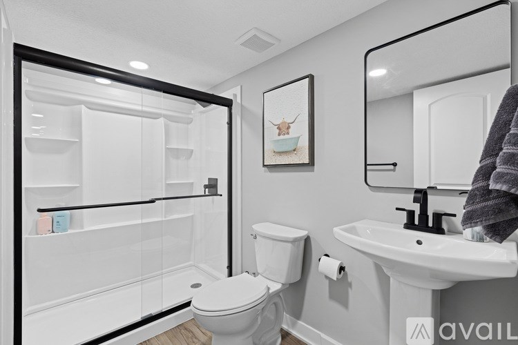 A bathroom with a toilet, sink, and a mirror.