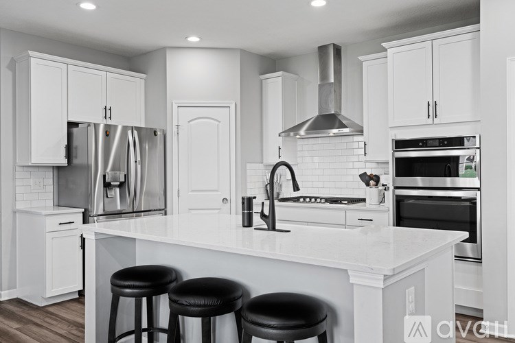 A modern kitchen with white cabinets and a central island.