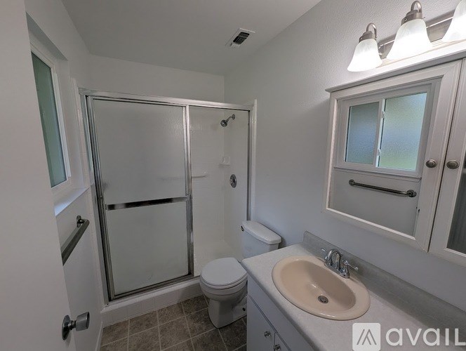 A bathroom with a toilet, sink, and shower.