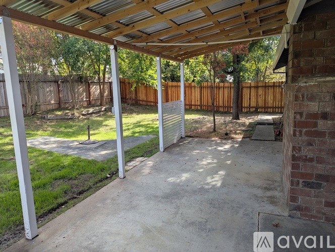 A patio with a wooden roof and white pillars.