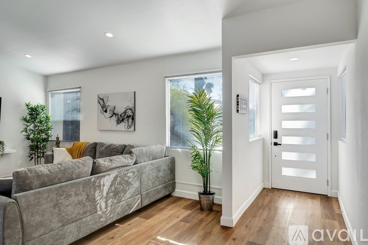 A living room with a grey couch and a white door.