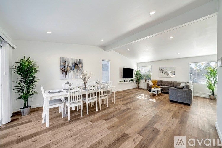 A spacious living room with a dining table and chairs.