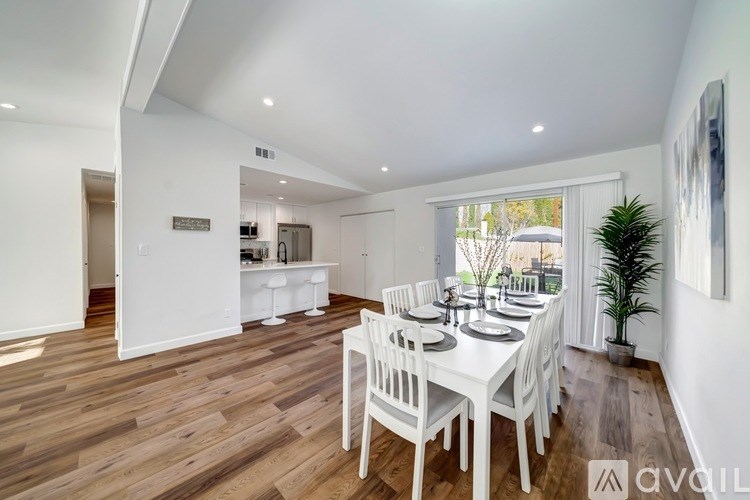A dining room with a white table and chairs.