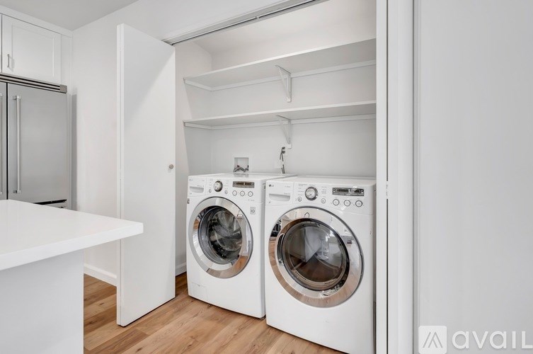 A laundry room with two front loading washing machines.