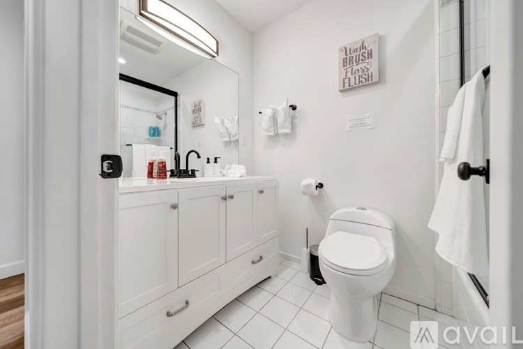 A white bathroom with a toilet, sink, and mirror.